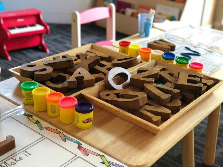 Colorful letters and playdough on a children’s table at Paramus Preschool & Daycare in Bergen County, NJ, highlighting hands-on, play-based learning in a nurturing classroom environment.